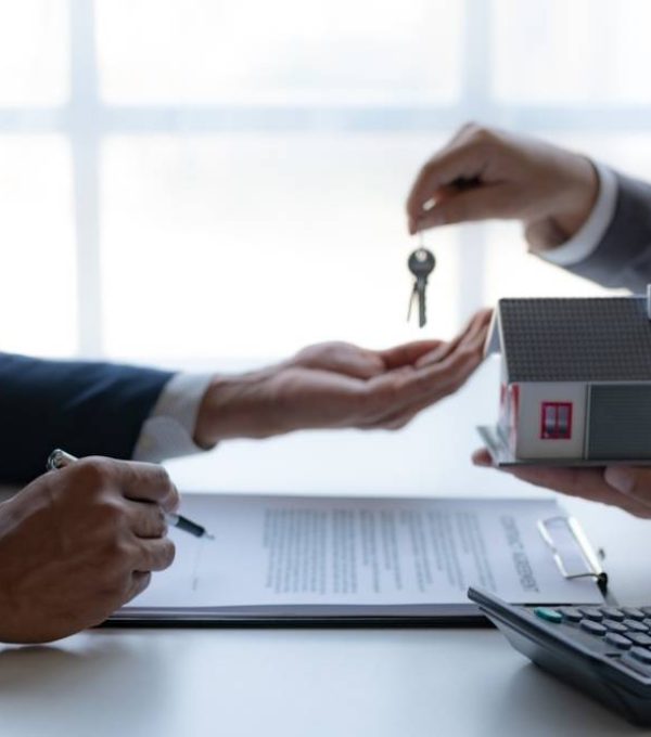 Real-estate-transaction-with-agent-giving-house-keys-to-client-over-a-contract